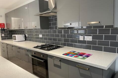A modern and spacious kitchen with sleek grey c...