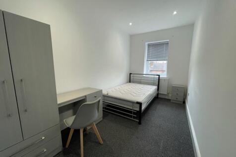 A spacious and tidy double bedroom with modern ...