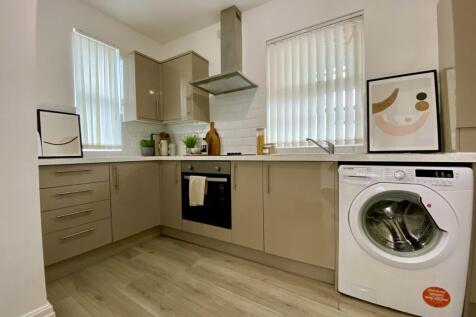 A modern and tidy kitchenette with ample storag...