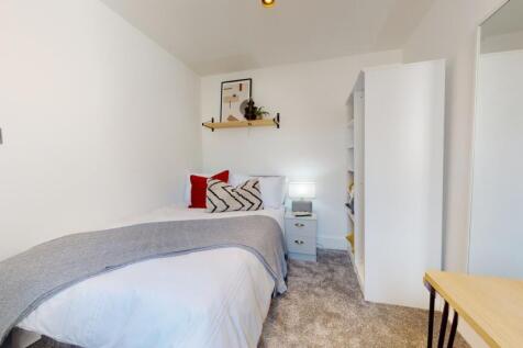 A bright and cozy double bedroom featuring mode...