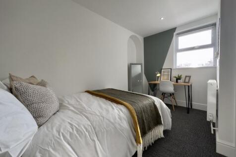A bright and tidy double bedroom featuring a co...