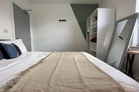 A cozy and well-arranged double bedroom with a ...