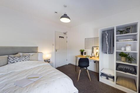 A bright and stylish double bedroom featuring a...