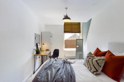 A bright and inviting double bedroom with styli...