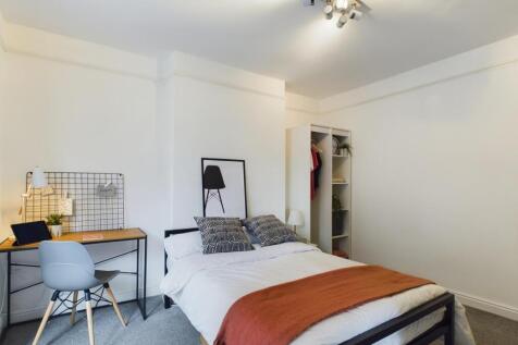 A spacious and bright double bedroom featuring ...