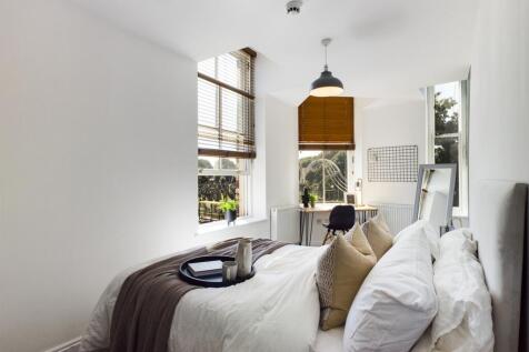 A bright and inviting double bedroom with styli...