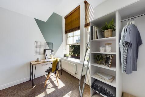 A bright and stylish double bedroom with a cozy...