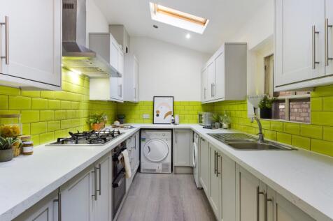A bright and modern kitchen with vibrant green ...