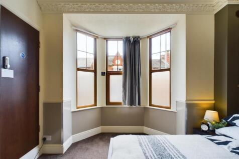 A bright and inviting double bedroom with large...