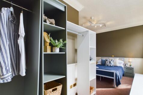 A spacious and tidy double bedroom featuring st...