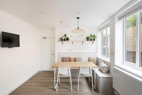 Bright, modern dining nook with a wooden table,...