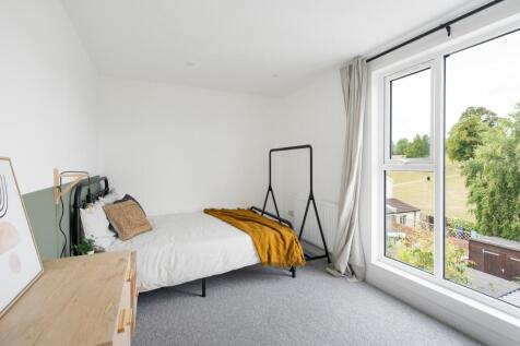 A bright and tidy double bedroom with a large w...
