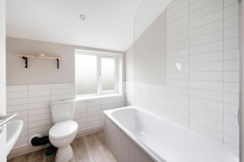 Bright, modern bathroom with a bathtub and show...