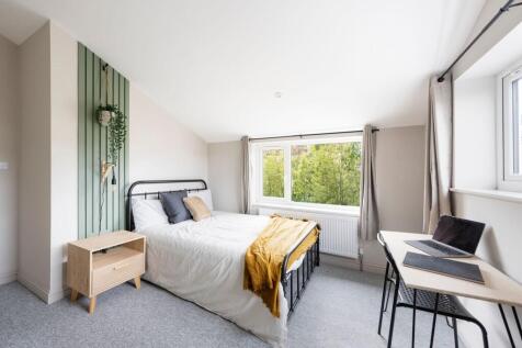 Bright, neatly styled double bedroom with a met...
