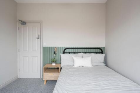 Bright, tidy bedroom with a metal-framed double...