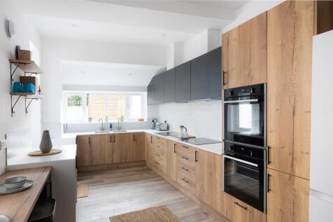 A bright and modern kitchen featuring stylish c...