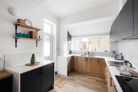 A bright and modern kitchen with ample storage ...