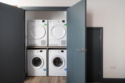 Neat built-in laundry closet with a stacked was...