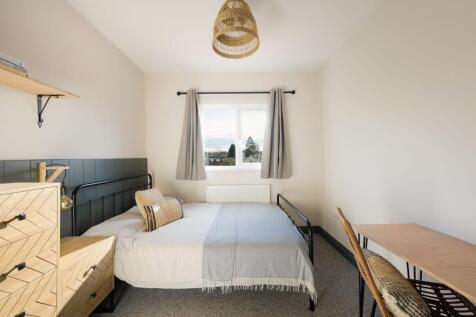 Bright, neatly staged double bedroom with a com...