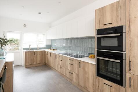 A clean and bright kitchen featuring modern app...