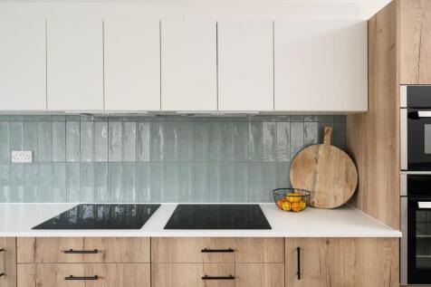 Contemporary fitted kitchen with light wood cab...