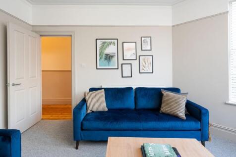 Bright, modern living room with a stylish deep-...