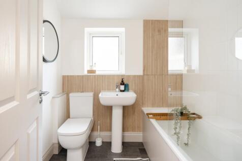 A modern and clean bathroom featuring a bath, s...