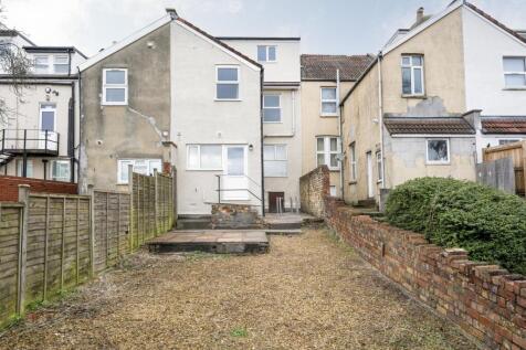 The back view of a house with a spacious garden...