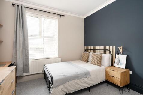 Bright, neatly styled double bedroom with a chi...