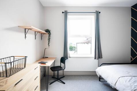 Bright, minimalist bedroom with a neat desk by ...