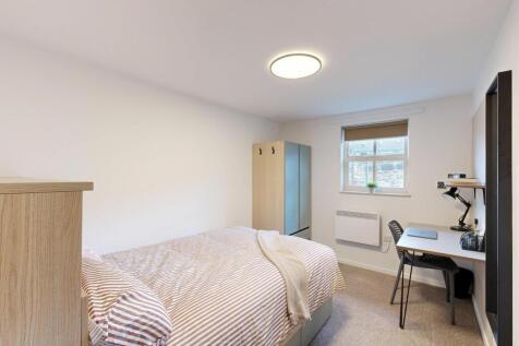 A cozy single bedroom featuring a comfortable b...