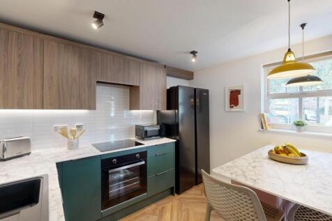 Modern and well-lit kitchen featuring sleek cab...