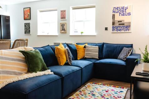 Bright, stylish living room with a large navy s...