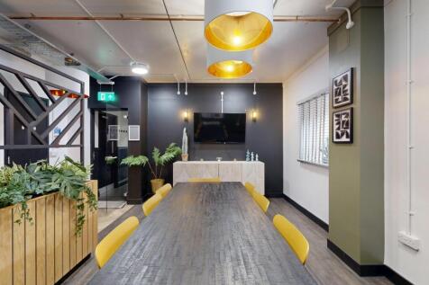 Bright, modern communal workspace with a long c...