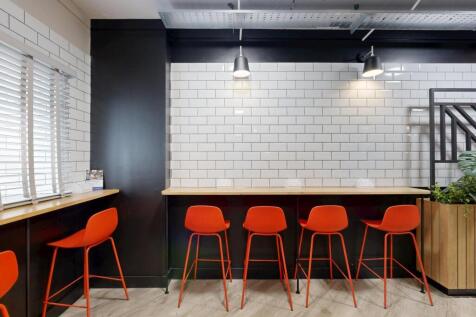 Bright, modern communal lounge with a long coun...