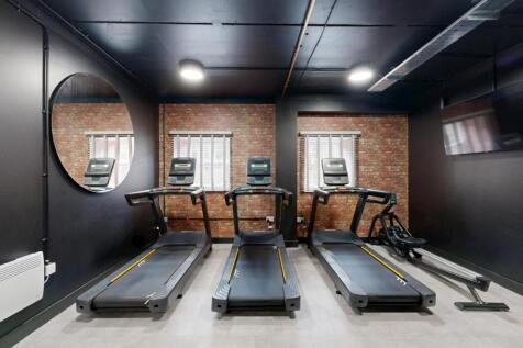 Modern on-site gym with three treadmills, expos...