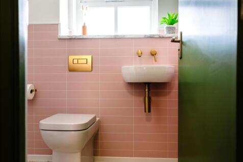 Bright, well-kept bathroom with tasteful pink w...