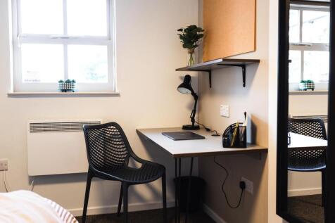Bright, tidy bedroom corner with a window, comp...