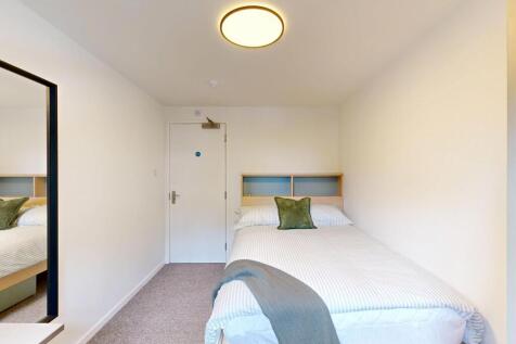Bright, simply furnished bedroom with a neatly ...