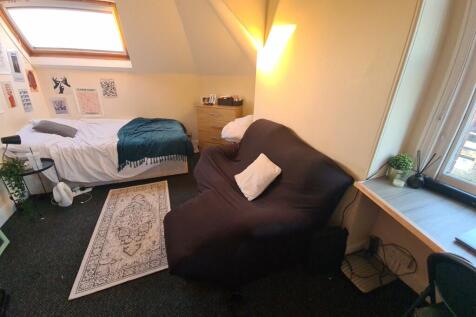 Cozy single bedroom featuring a comfortable bed...