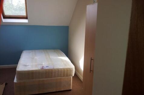 A cozy single bedroom featuring a comfortable b...