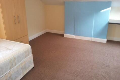 A neat and simple bedroom featuring a single be...