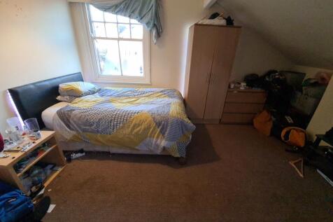 A cozy attic bedroom with a single bed position...