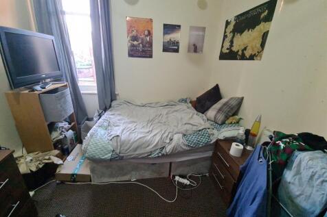 Cozy bedroom featuring a neatly made bed with s...