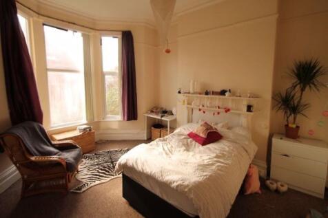 A bright and cozy master bedroom featuring a co...