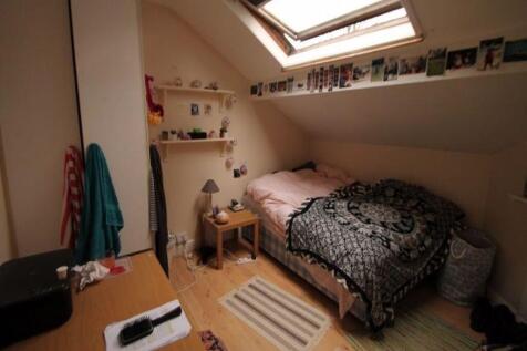 Cozy single bedroom featuring a skylight that a...