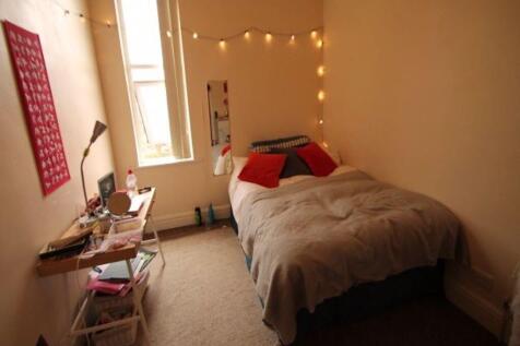 A cozy single bedroom featuring a comfortable b...