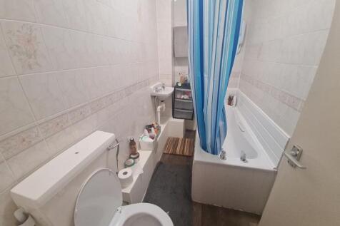 A neat and functional bathroom featuring a whit...