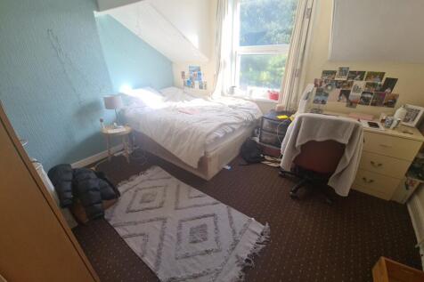 Cozy single bedroom with a large window providi...