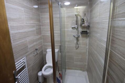 A modern bathroom featuring a glass-enclosed sh...